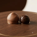 Duo de melo-cakes artisanaux enrobés de chocolat au lait et de chocolat noir sur socle en bois.